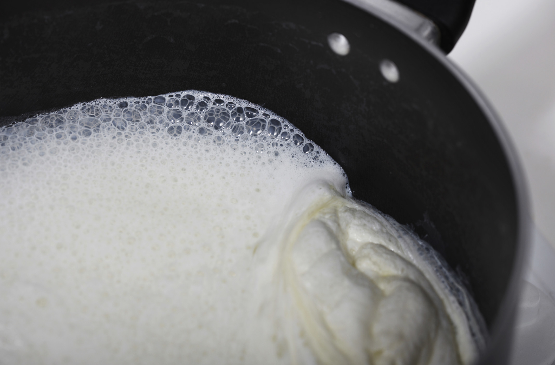 Milk boiling in a saucepan.