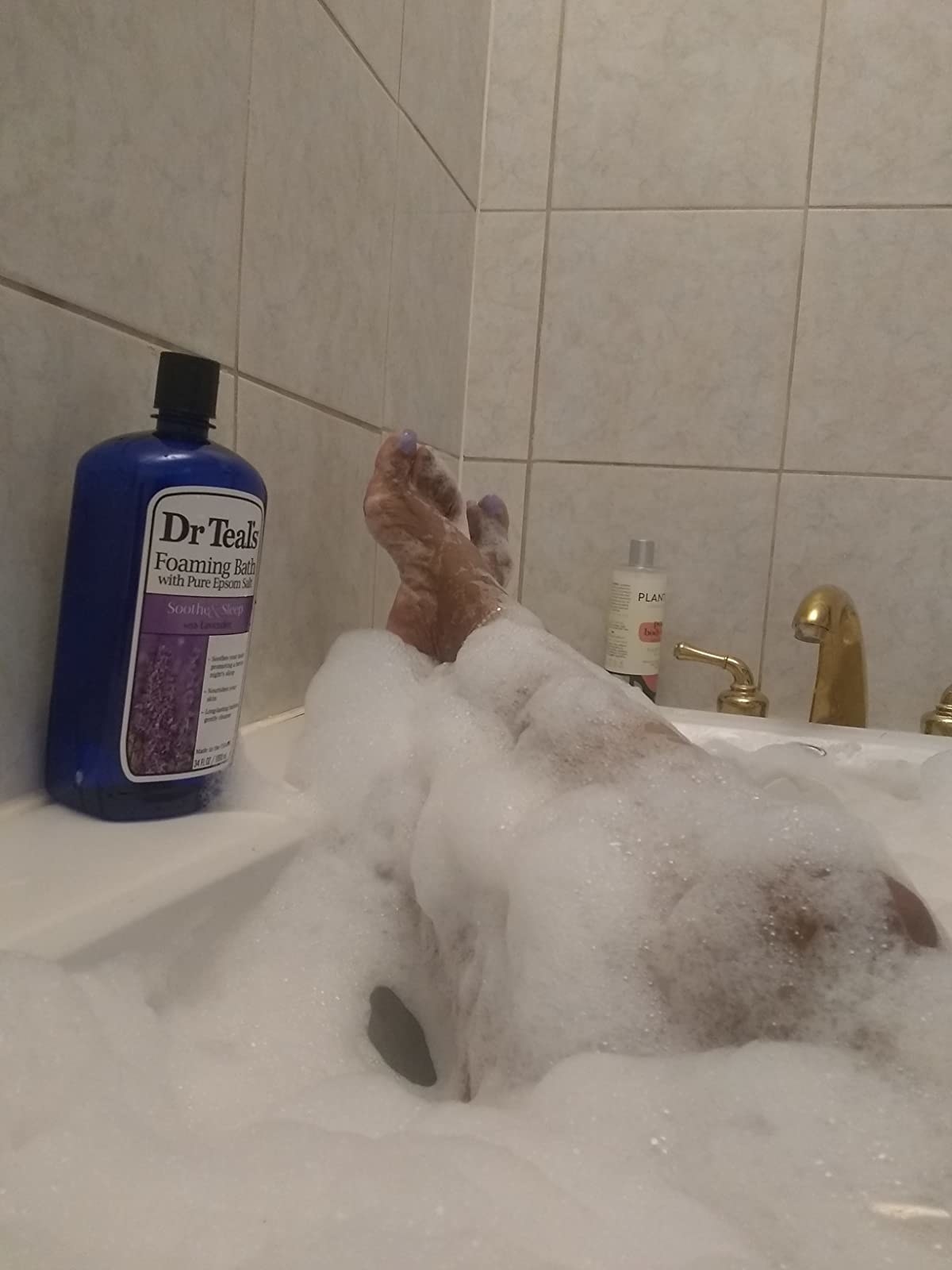 image of reviewer&#x27;s legs in a bubbly bath after using dr teals foaming bath