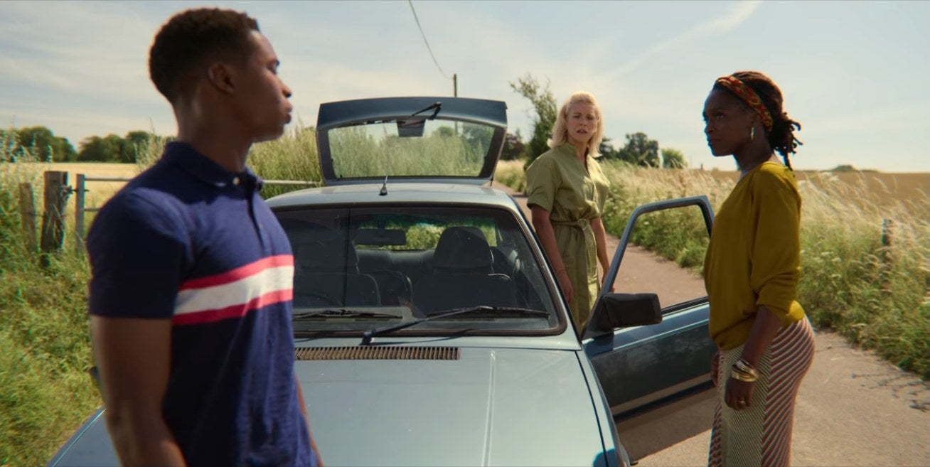 Jackson stands near a car with his two moms.