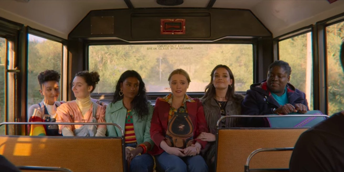 Ola, Lily, Olivia, Aimee, Maeve, and Viv ride in the back of a bus.