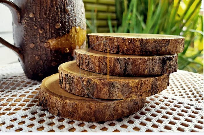 Four wooden bark coasters stacked on top of each other on a table.