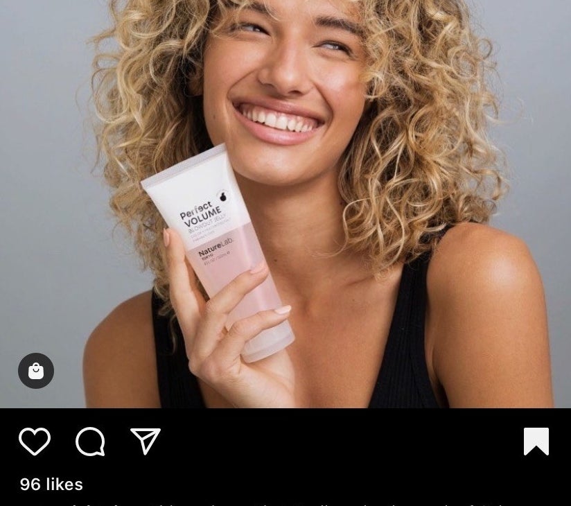 Reviewer with curly hair holding the volumizing jelly