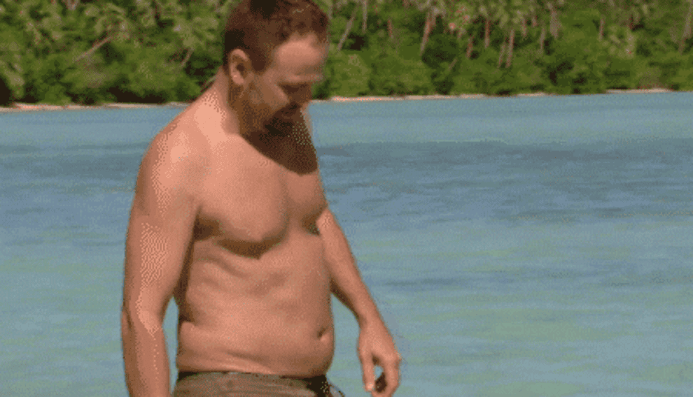 Gif of man sitting in water and dunking his head on Survivor 