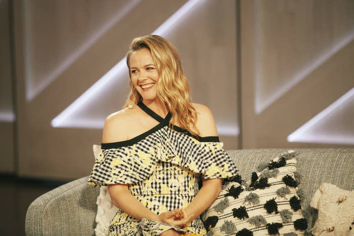 Alicia Silverstone smiles and sits on a couch on set of &quot;The Kelly Clarkson Show&quot;