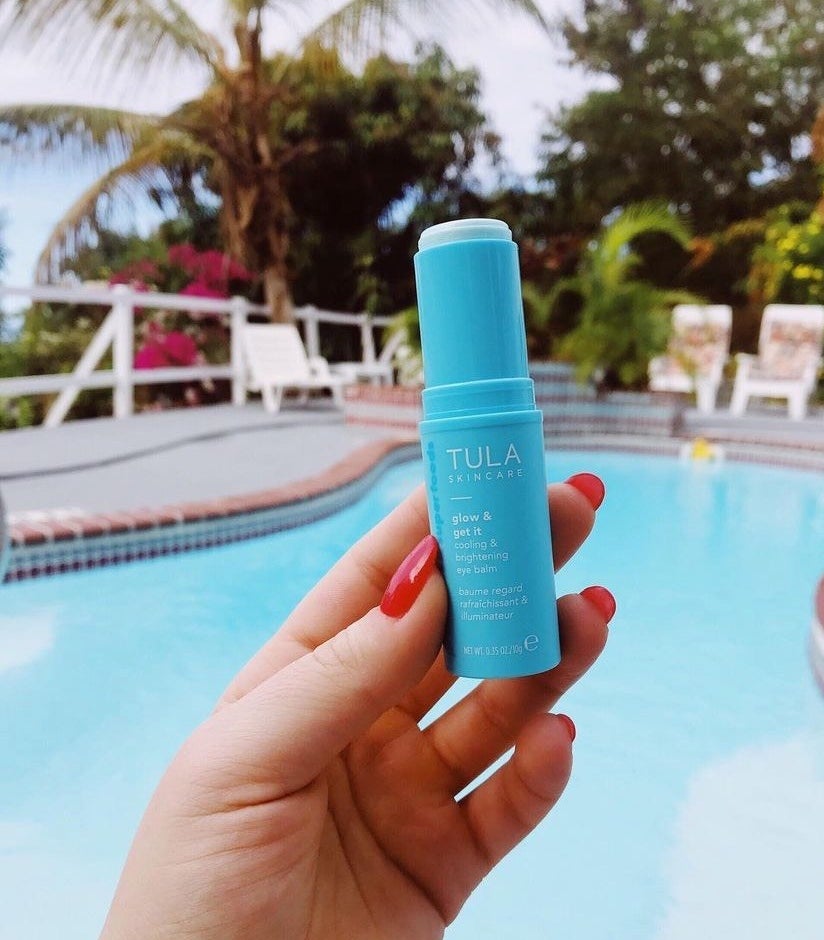 Model holding the cooling eye stick in lip balm-like packaging