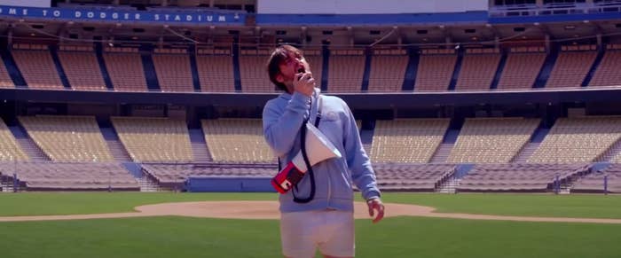 A man singing alone in the middle of the Dodger Stadium field