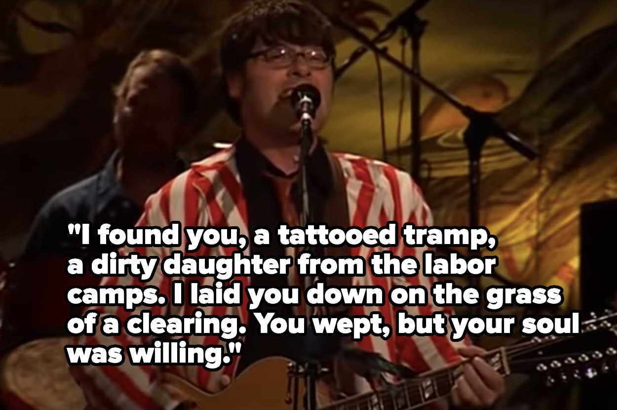 Man singing into a microphone about how &quot;I found you,  a tattooed tramp, a dirty daughter from the labor camps&quot;