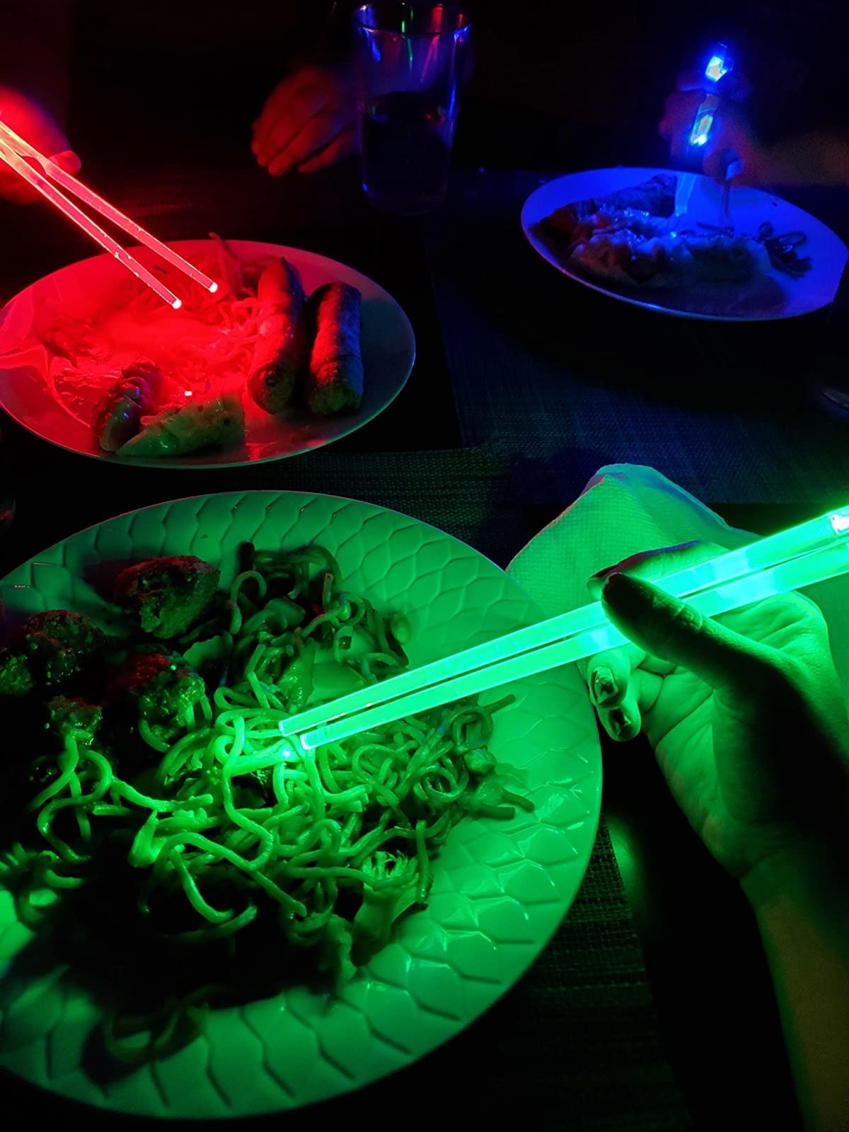 reviewer image of three people eating chinese food with lit up light saber chopsticks