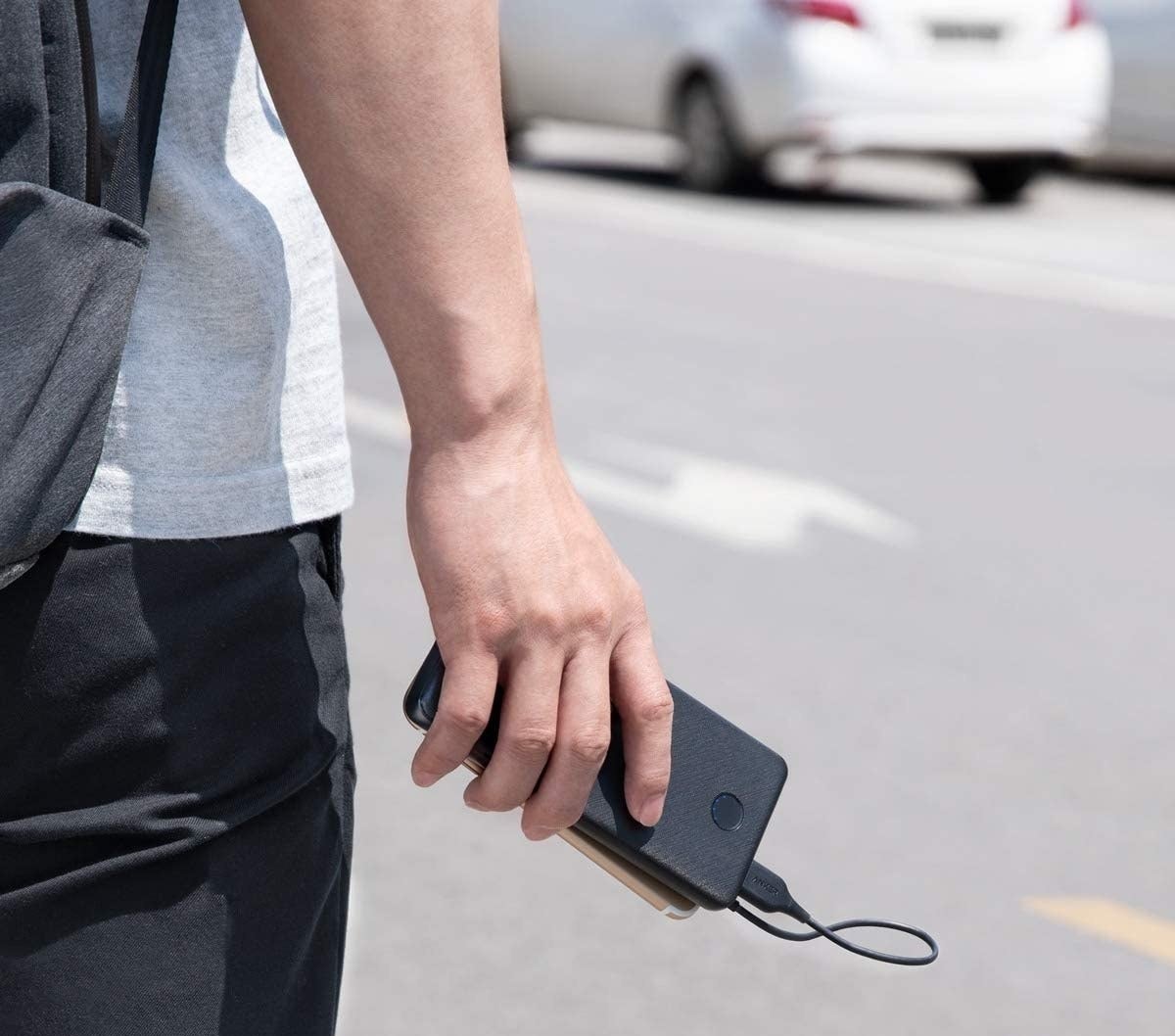 Model holding black charger battery pack in hand