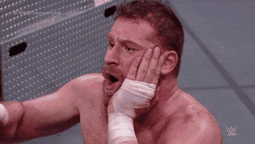 Wrestler holding his mouth in pain
