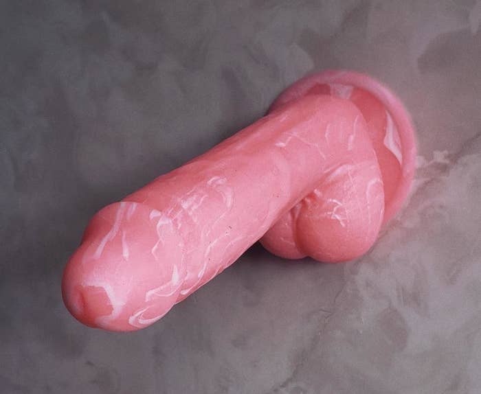 Pink marbled silicone dildo attached to wall
