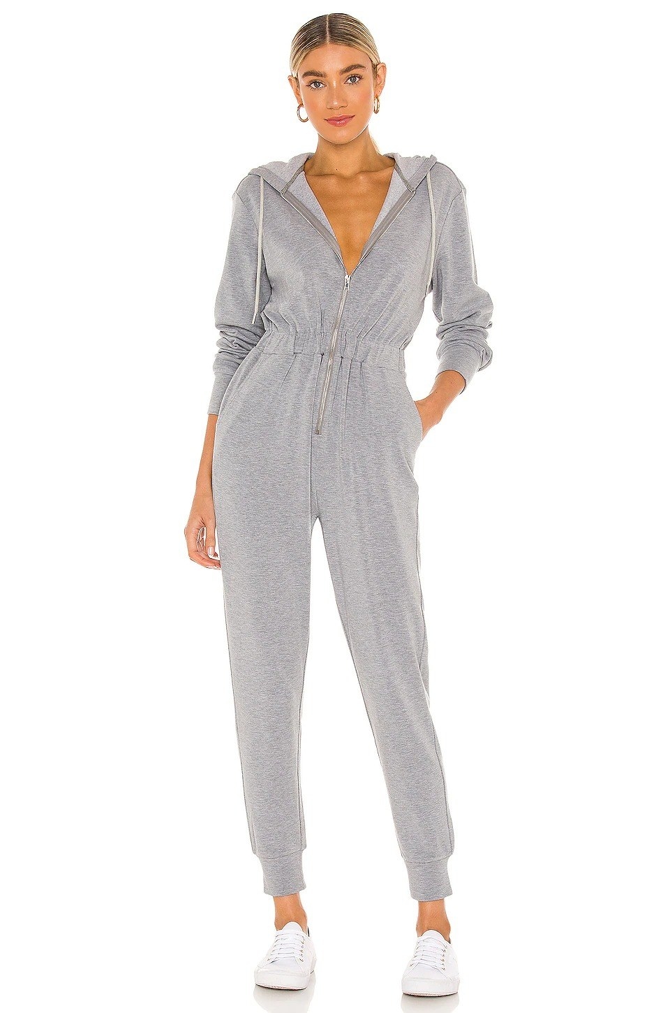 Model wearing gray jumpsuit cuffed at the ankle with an elastic band and silver zipper