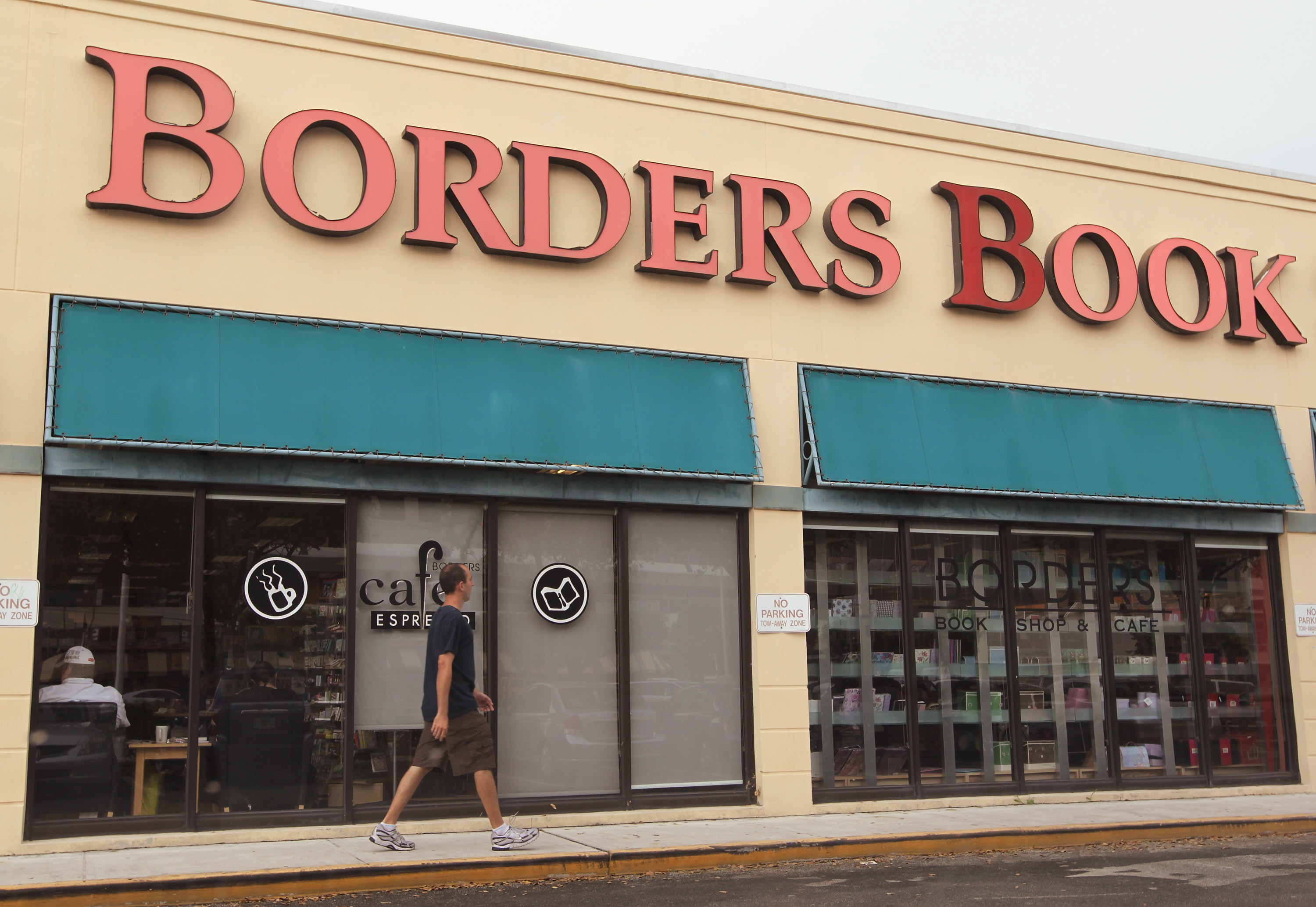 Exterior of a Borders Books with a man walking by it