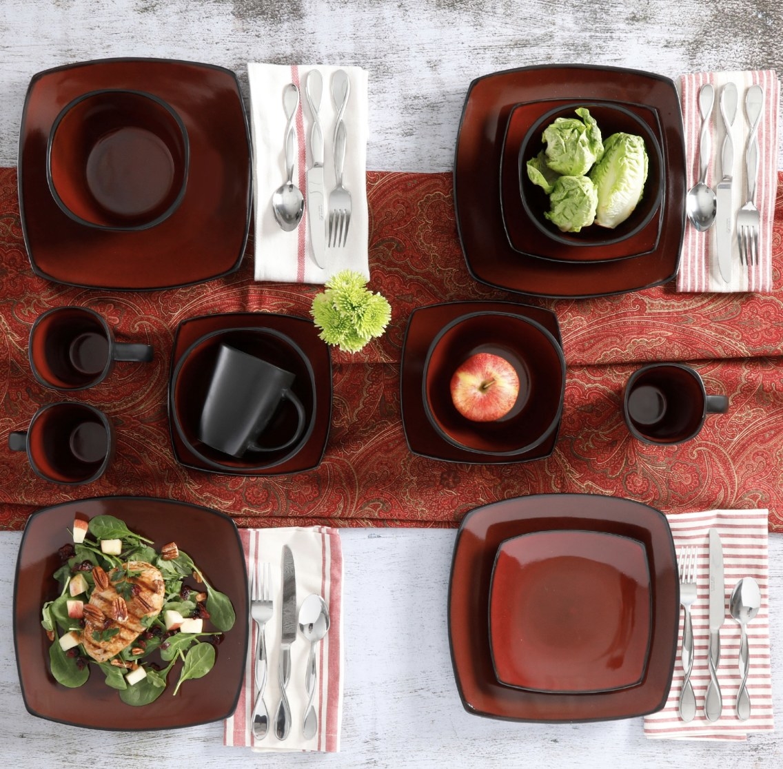 The deep red and black dinnerware set has four place settings and various foods