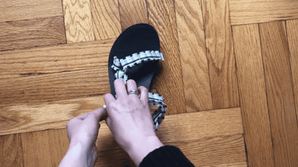 gif of buzzfeed editor adjusting the velcro toe and ankle straps on a teva sandal