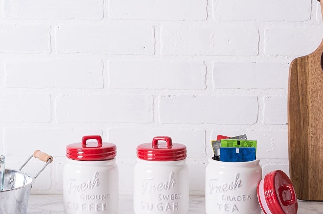 A trio of ceramic canisters that say coffee sugar and tea on them