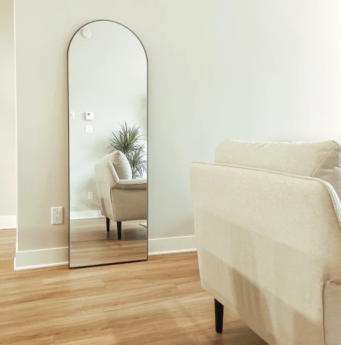 A reviewer&#x27;s floor length mirror against a wall in a living room