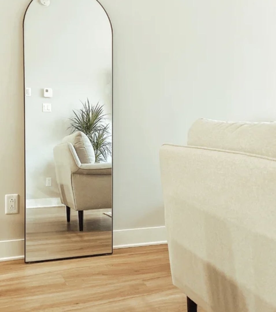 A reviewer&#x27;s floor length mirror against a wall in a living room