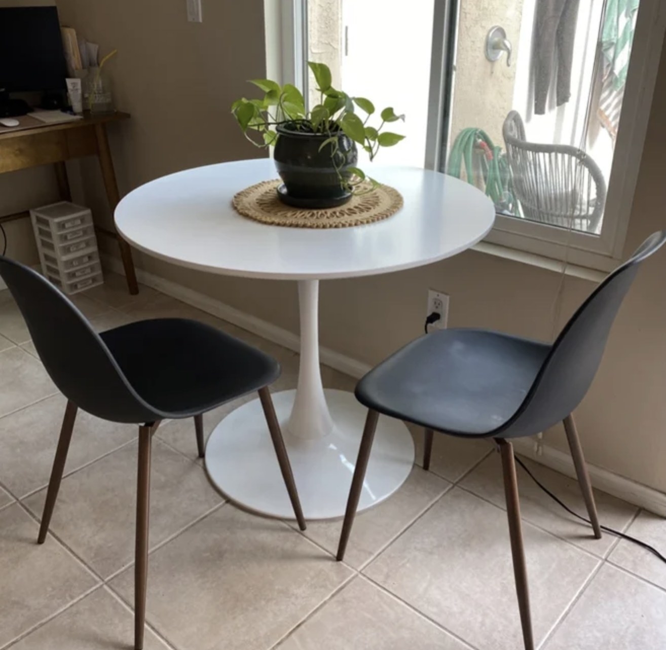 A reviewer&#x27;s white pedestal dining table with chairs next to it