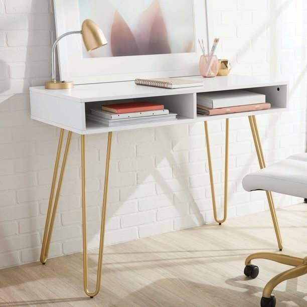 white writing desk with gold legs on the bottom