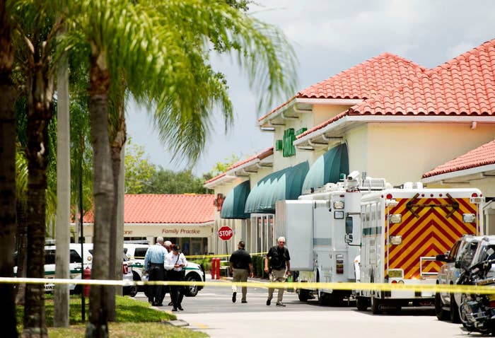 Police inspect the crime scene behind a police line