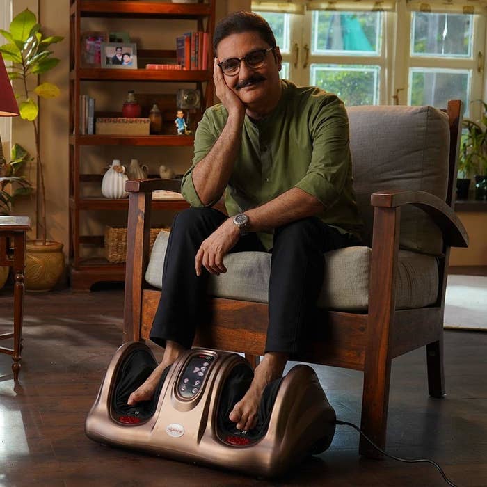 A man sitting on a chair with the foot massager