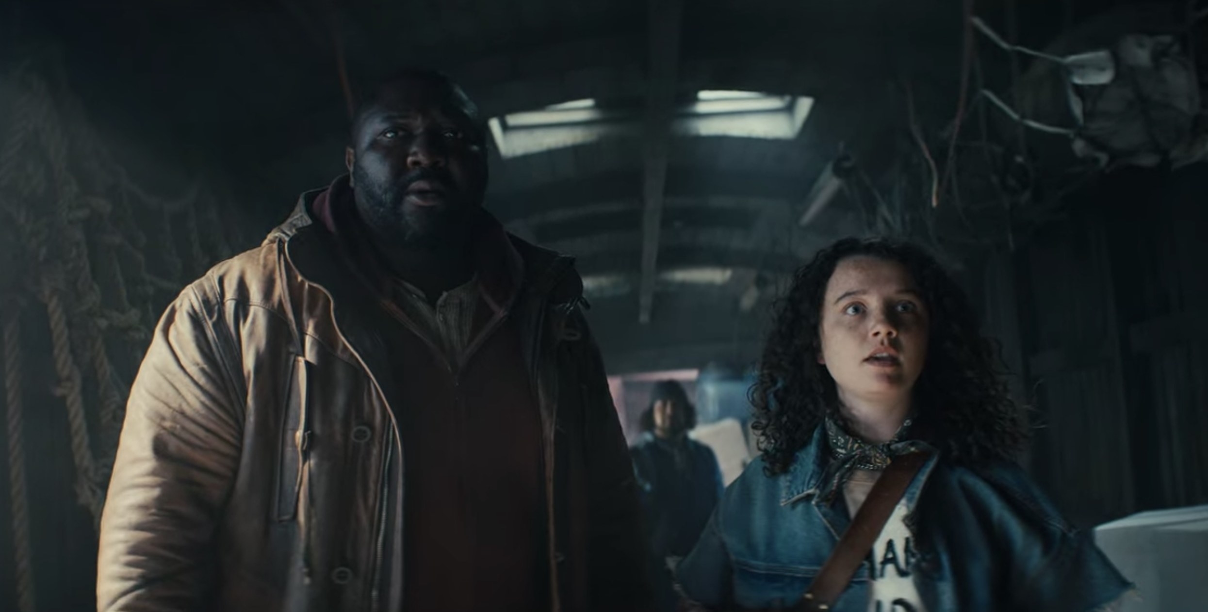 Jepp and Bear in the darkened interior of a train, looking unpleasantly surprised