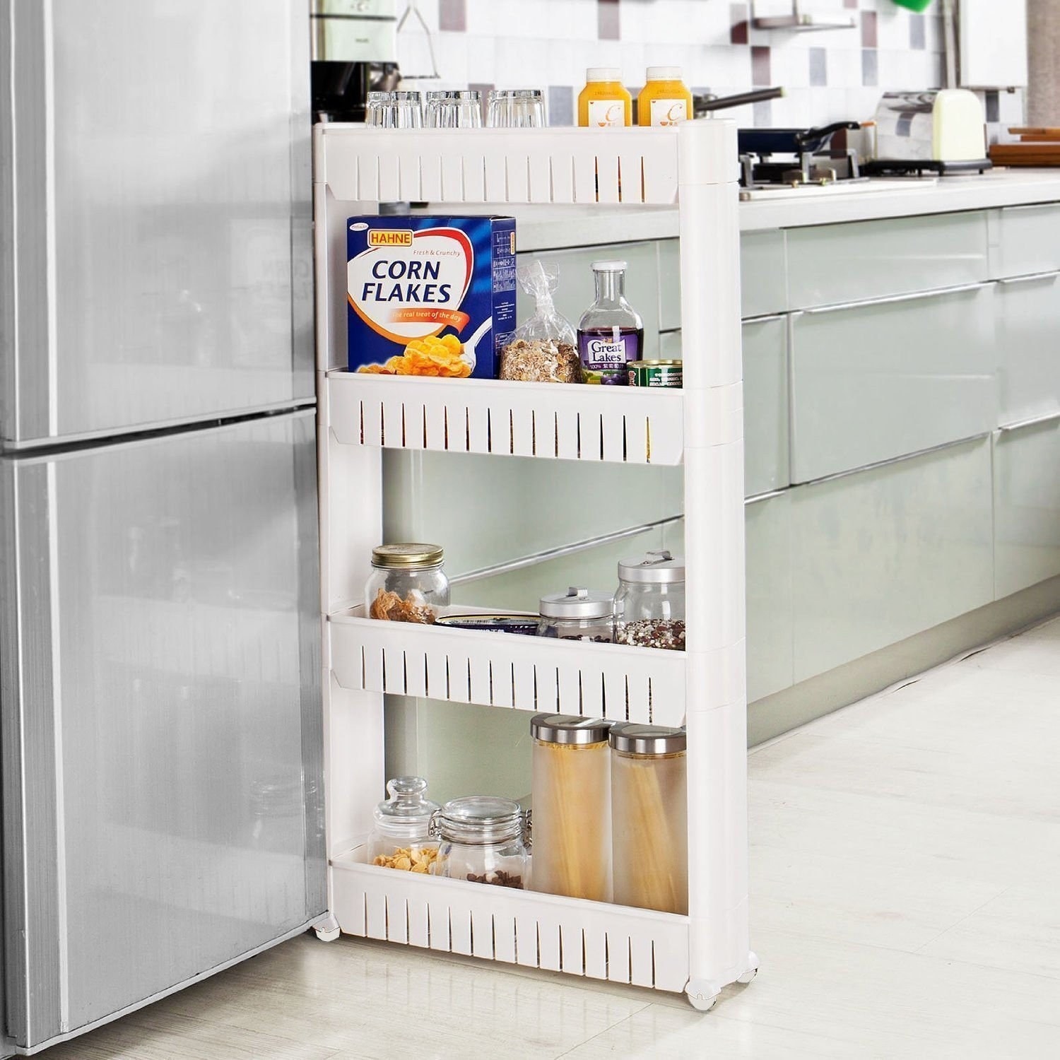 A slim rack with food items in it being wheeled into the space between a fridge and a counter 