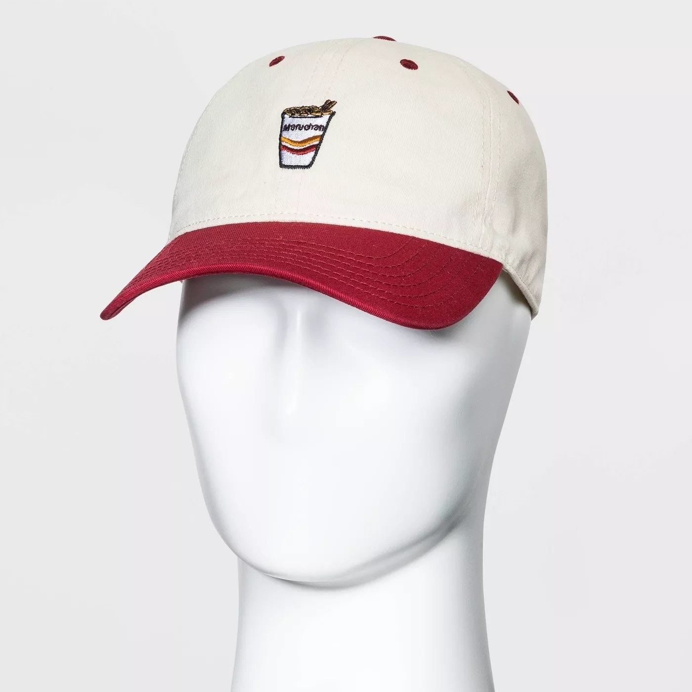 The beige and red cap with a ramen cup stitched onto it