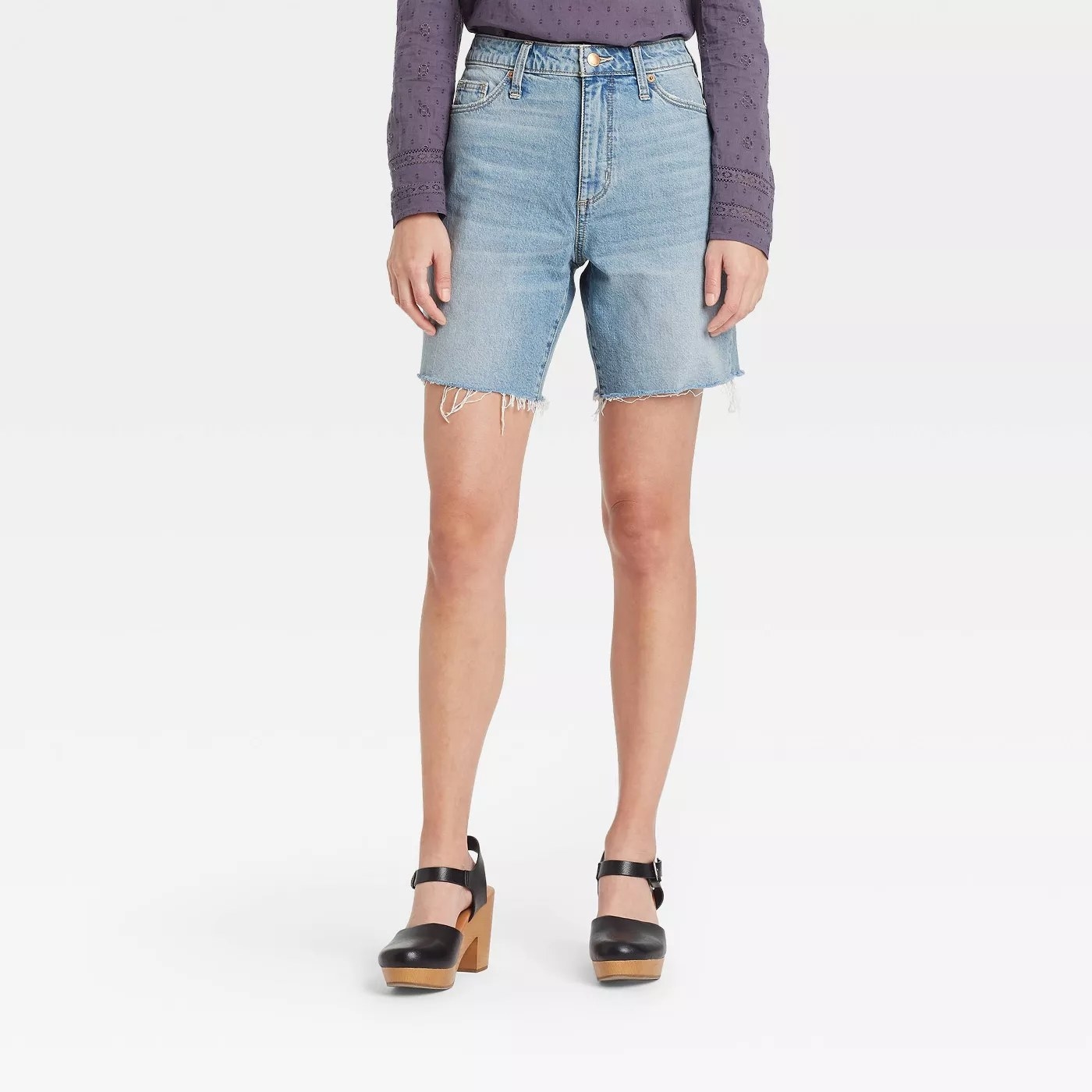 A model wearing the light blue cutoff jean shorts