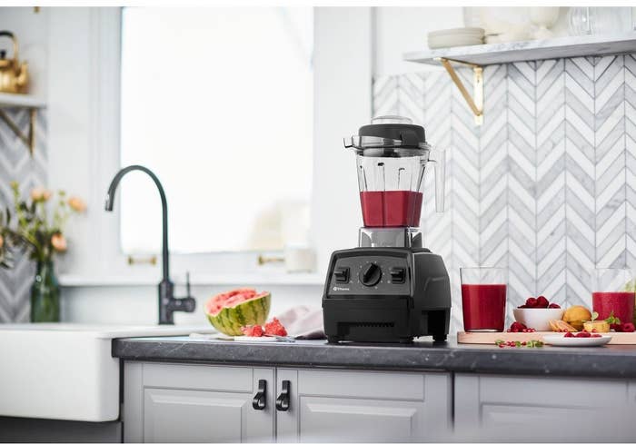 black vitamix blender on a counter with red fruit juice inside