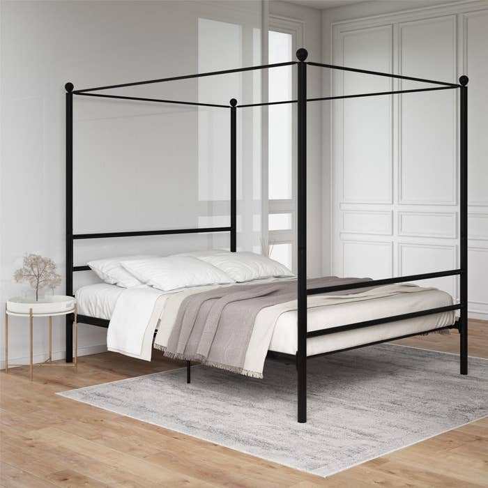 a black canopy bed in a bedroom