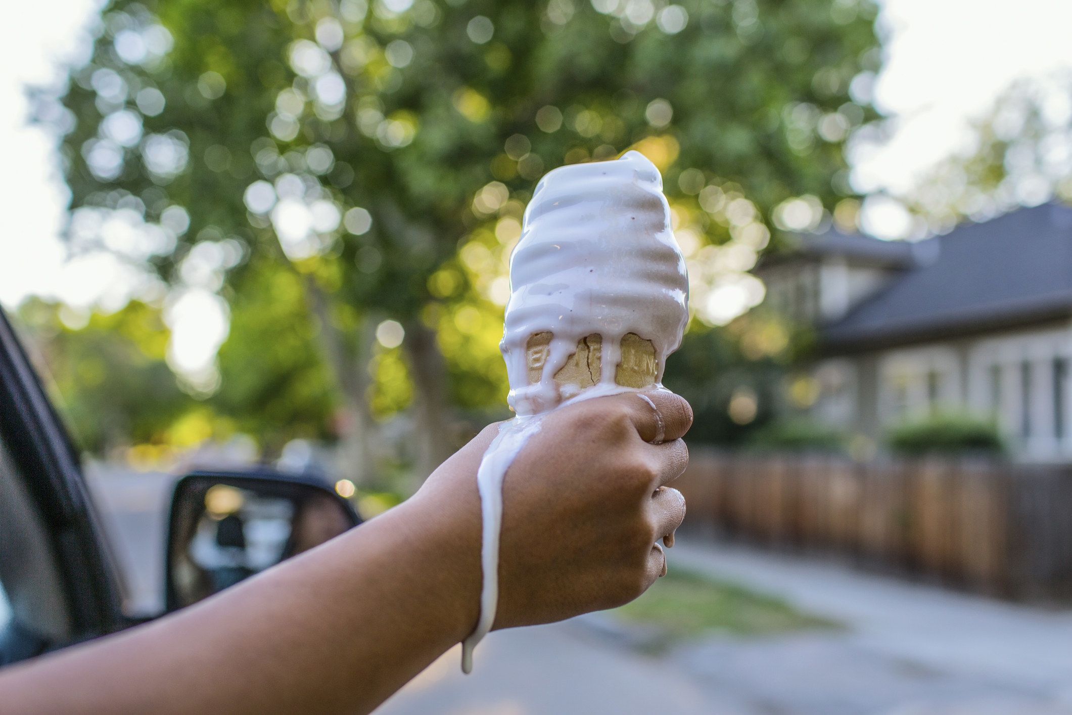 Someone holding a melting ice cream cone.
