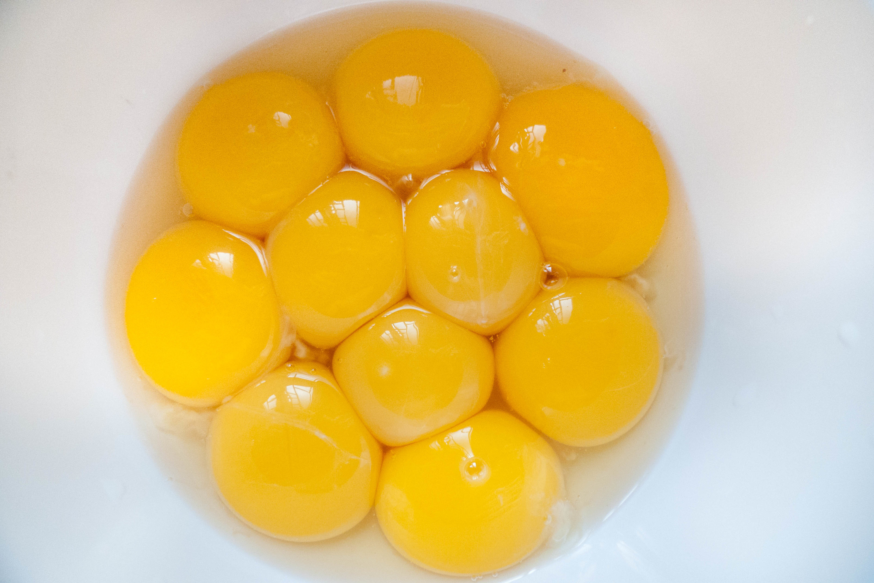 A handful of raw egg yolks in a bowl.