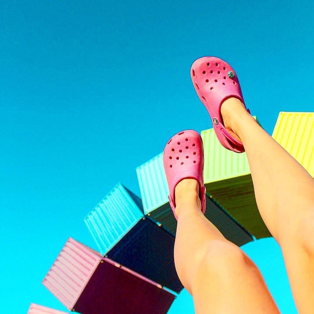 A person lifting their legs toward the sky showing off their crocs 