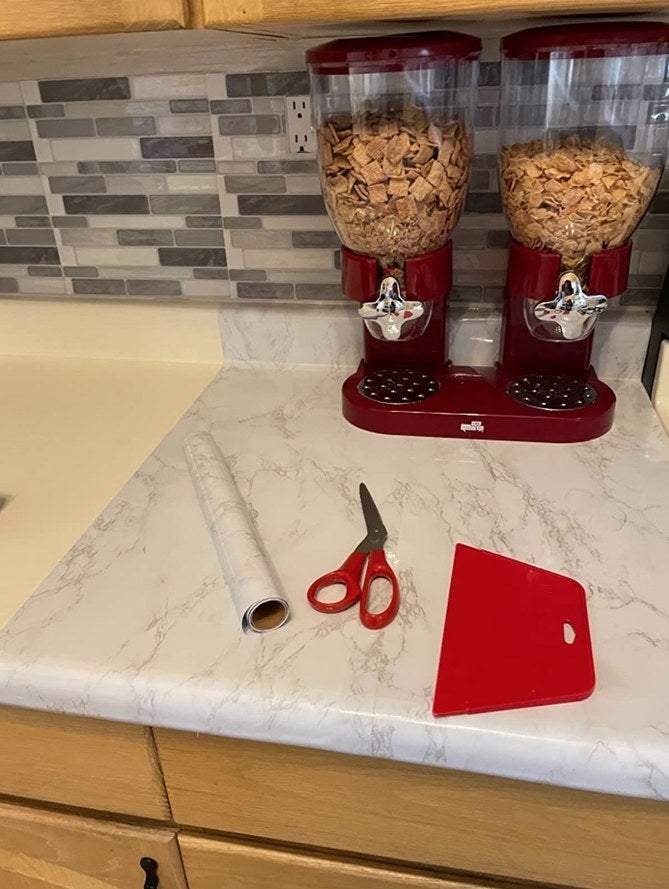 reviewer with red wallpaper tools on kitchen counter