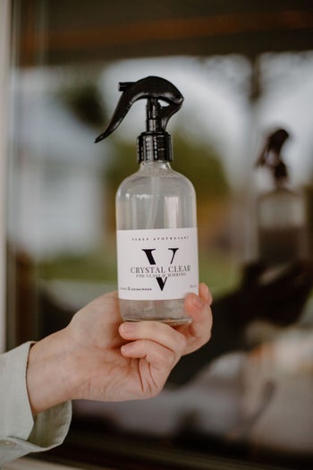 Model holding bottle of Viren Apothecary glass and mirror polish