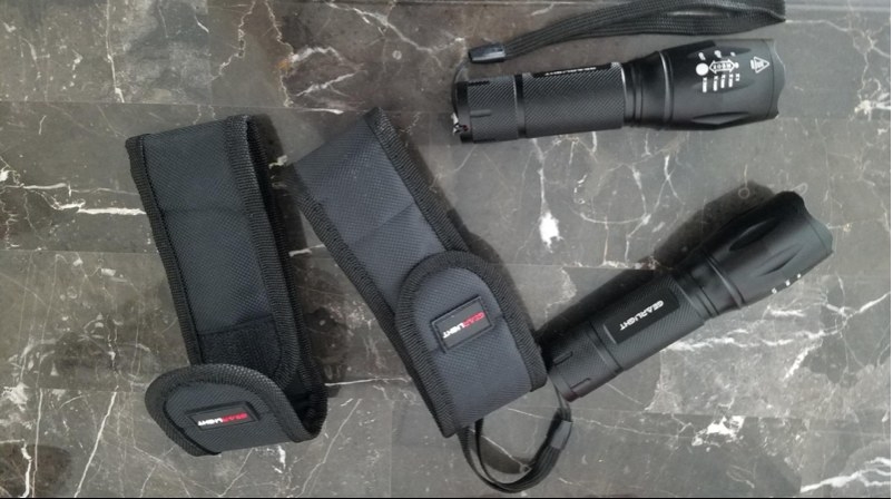 Two black flashlights with storage pouches
