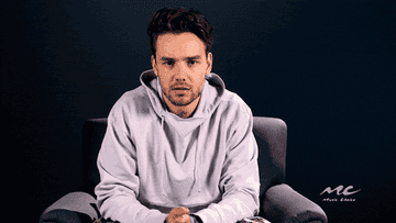 Liam Payne shrugs and looks confused in this gif