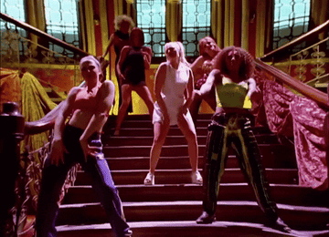 The Spice Girls dance on a staircase