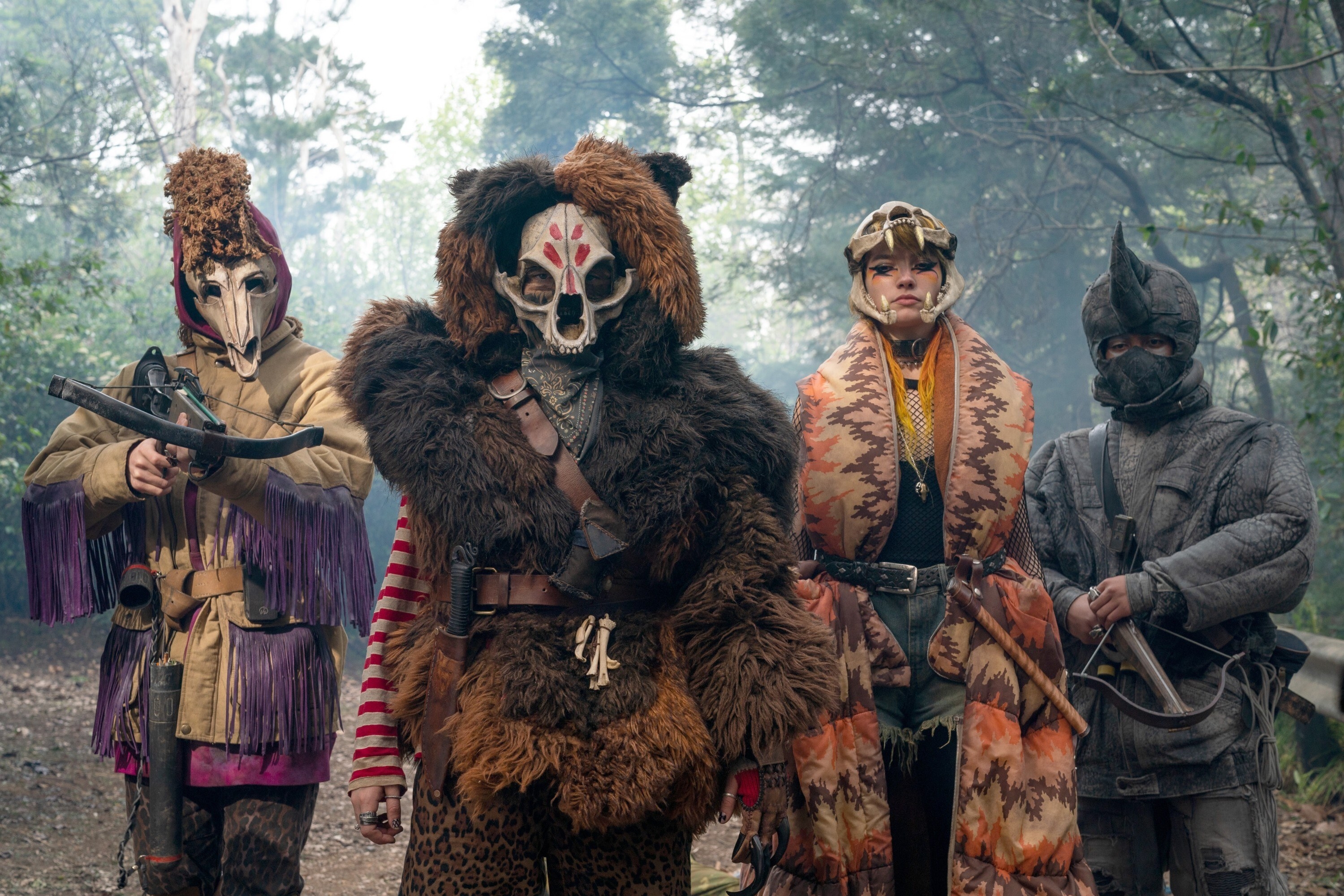 Members of the animal army looking ready for battle, dressed in bulky outfits with animal headdresses, holding weapons, with Bear in the center. 