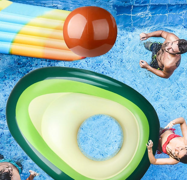 people playing around the avocado float and tossing the pit beach ball