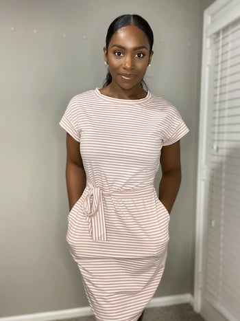 reviewer wearing the pink striped dress with a tie waist