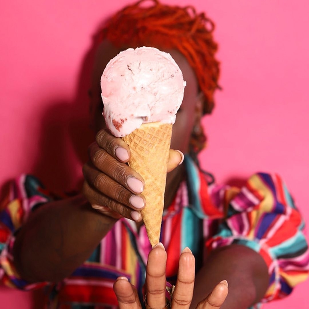 A person with a strawberry ice cream cone