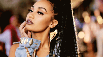 Leigh-Anne Pinnock looks directly to camera and moves her hand down her chin