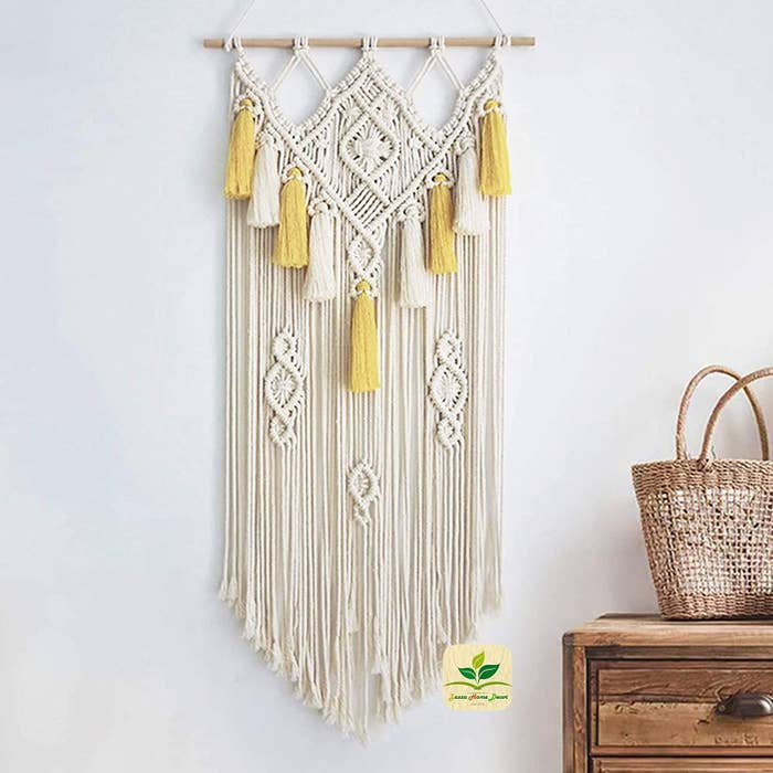 A Beige and yellow macrame wall hanging.