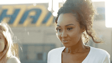 An angelic Leigh-Anne Pinnock smiles and looks down in this gif
