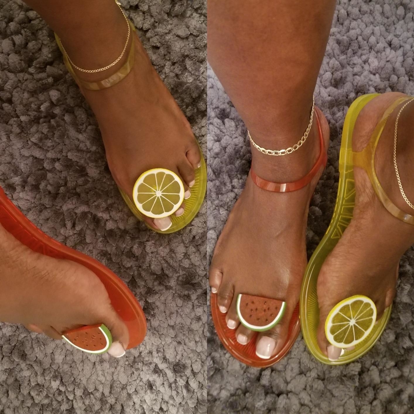 A reviewer models the sandals in the lemon and watermelon styles