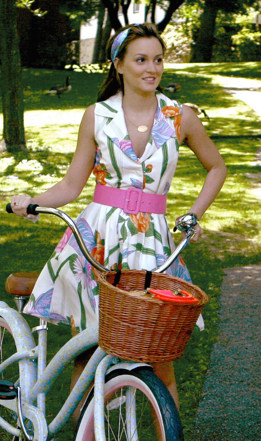 Blair in a v neck collared sleeveless floral print dress with a flare skirt and a bright thick belt at the waist