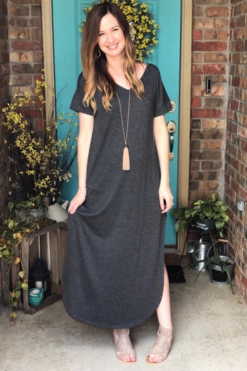 reviewer wearing the gray maxi dress and a long necklace